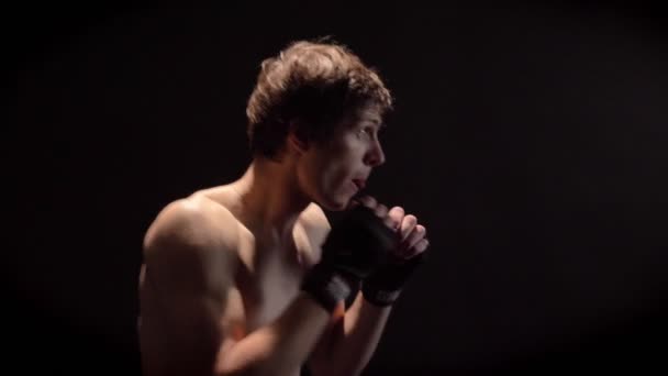 Молодой белый топлесс боксер бокс, джеб, удар, черный фон, вид сбоку 50 кадров в секунду — стоковое видео