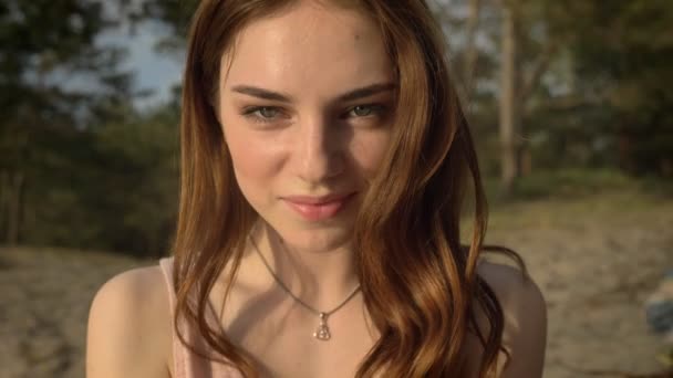 Portrait of a young ginger smiling girl in nature, blowing sand from hands to the camera 50 fps — Stock Video