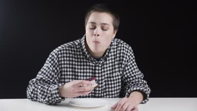 Genç sıradışı kız cheescake yiyor, parmak yalama, gebe, siyah arka plan diyet