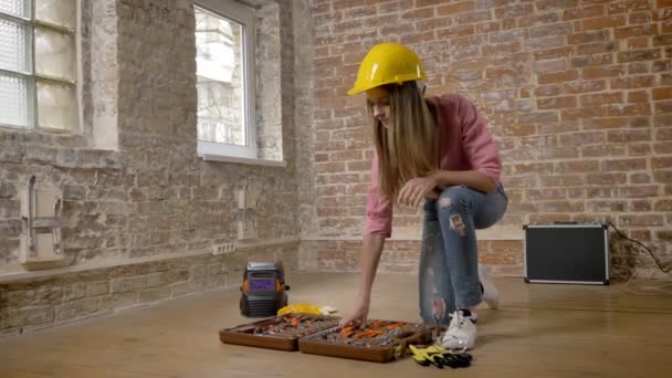 Giovane ragazza seria costruttore sta prendendo strumenti da cassetta degli attrezzi, costruzione di concezione — Video Stock