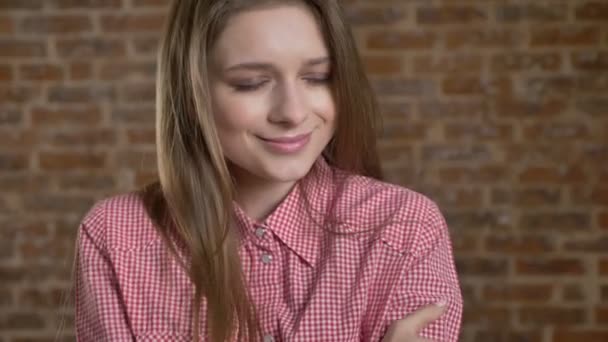 Genç Sevimli kız kendini, gözler, tuğla arka plan kapanış hugs — Stok video