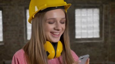 Genç Sevimli kız Oluşturucu gülüyor, iletişim anlayışı onun smarphone izliyor