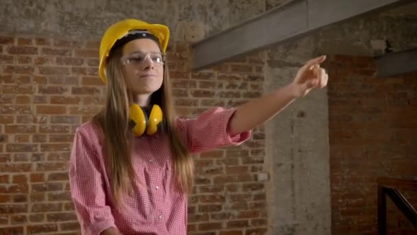 Fiatal magabiztos lány buitder rámutat arra, hogy a munka, és áthalad a kezét, nem ért egyet a jele, építési koncepció, tégla háttér — Stock videók