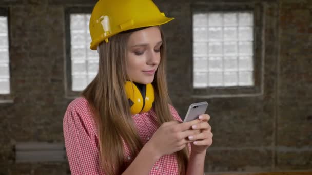 Fiatal szép lány builder egy SMS üzenet, ő okostelefon, a kommunikáció fogalma — Stock videók