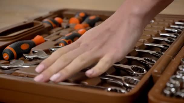 Ragazza costruttore tocca gli strumenti nella cassetta degli attrezzi con la mano, riparando concepimento — Video Stock