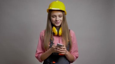 Genç güzel kız Oluşturucu gülümseyen iletişim kavramı, gri arka plan ona telefon ekranının renk gösterilen