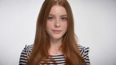 Kameraya gülümseyen, beyaz arka plan bir şirin gignger genç kız portresi