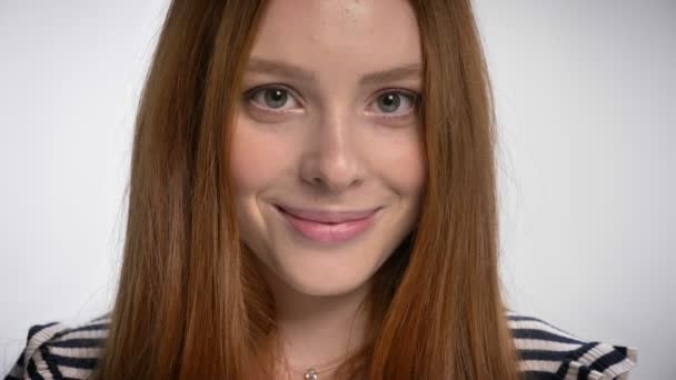 Portrét gignger roztomilé dospívající dívka při pohledu na fotoaparát s úsměvem, bílé pozadí — Stock video