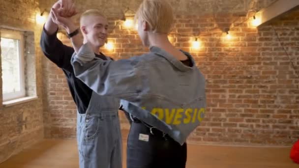 Joven pareja moderna de hipsters están bailando, besándose, concepto de amor, fondo de ladrillo — Vídeo de stock