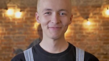 Olağandışı delikanlı hipster gülmeye devam ediyor, onun kız arkadaşım dans ve gülüyor, duygu kavramı, tuğla arka plan