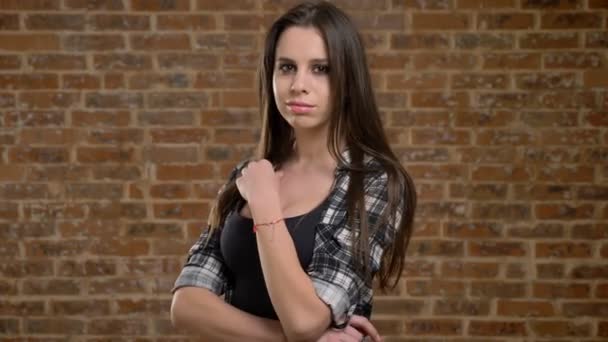 Young pretty beautiful women posing for camera and touching her long hair, female builder, brick background — Stock Video