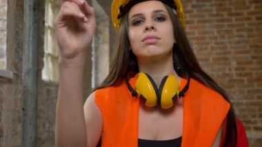 Bina arka plan kask ve kamera işaret ve biri kadın Oluşturucusu, davet kulaklık genç güzel çekici kadın tuğla