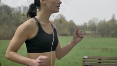 Genç motive kız yaz aylarında Park'ta jogging, dinleme müzik, sağlıklı yaşam, spor anlayışı, yan görünüm