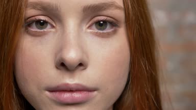 Güzel üzgün beyaz zencefil kız portresi, arka planda tuğla duvar