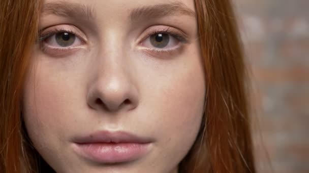 Porträtt av vackra ledsen kaukasiska ingefära flicka, tegel vägg i bakgrunden — Stockvideo
