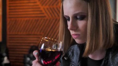 Ağır ile siyah ceketli genç güzel kadın kararlı, içki şarap kadar kafe arka plan yapmak..