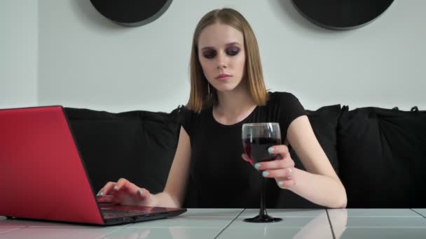 Όμορφες κοπέλες με βαρύ μακιγιάζ χρησιμοποιώντας φορητό υπολογιστή και να πίνει κρασί, χαμογελώντας, μαύρο και άσπρο καφέ φόντο — Αρχείο Βίντεο