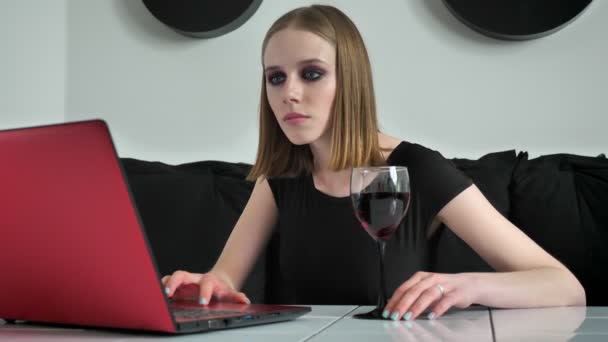 Mladé krásné ženy s těžkými tvoří pomocí přenosného počítače a pití vína, určeno, černé a bílé café pozadí — Stock video