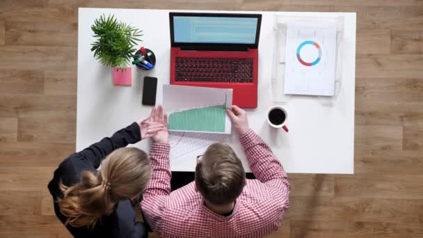 Jonge man in glazen praten met vrouwen over document topshot, Bureau met koffie en laptop — Stockvideo