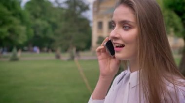 Genç Sevimli kız parkta telefonda konuşuyor yaz, duygusal kavramı, iletişim kavramı