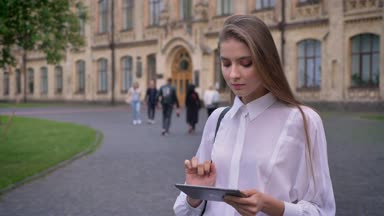 Gülümseyen, kameraya, iletişim kavramı izlerken genç çekici kız öğrenci yaz aylarında onun tablet üzerinde çalışır
