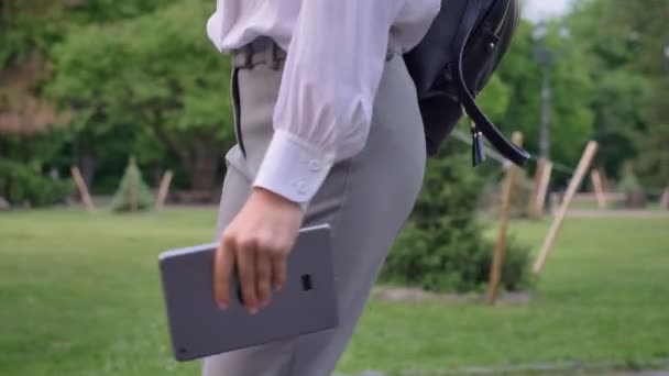 Junges ernstes Mädchen geht im Sommer mit Tablet in der Hand durch Park, Büroangestelltes Konzept — Stockvideo