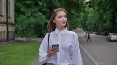 Genç güzel kız onun smartphone, yaz, parkta gidiş içinde iletişim kavramı izliyor