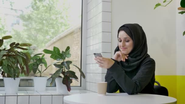 Ung Vacker Muslimsk Kvinna Hijab Håller Telefonen Och Chattar Mobila — Stockvideo