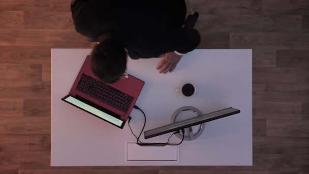 Chef weggaat en wanneer verlichting uitschakelen van jonge man binnenkomt en sluit zijn flash-drive en hacken laptop, top shot — Stockvideo