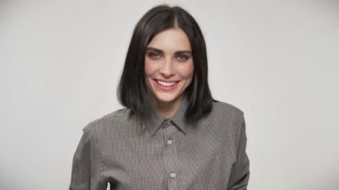 Genç kadın doğruca kameraya bakıyor ve gülümsüyor, mutlu, beyaz arka plan kısa saç kesimi ile güzel.