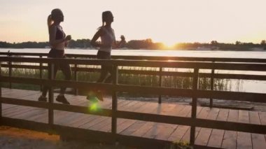 Parkta Köprüsü ve durdurma Nehri, yakınında günbatımı sırasında kilo kaybı, güzel görünüm çalışan iki genç kadının