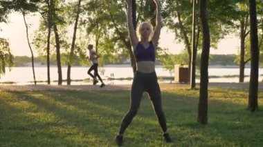 Park, kilo kaybı, atlama fitness modeli, sırt üstü, harika bir manzara çalıştıran diğer kadın yıldız egzersiz yaparak genç güzel kadın