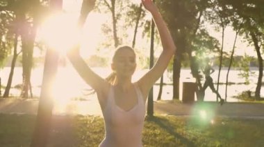 Genç kadın Parkı, fitness modeli atlama, sırt üstü çalıştıran diğer kadın yıldız egzersiz yaparak lens flare, güzel manzara