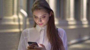 Genç çekici kız ileti, onun Smartphone'da akşam yaz, düşünme anlayışı, iletişim kavramı yazmakta olduğunu