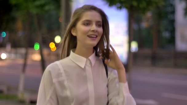 Junge schöne glückliche Mädchen geht durch sreet abends im Sommer, lächelnd, denkend Konzeption, zu Fuß Konzeption — Stockvideo