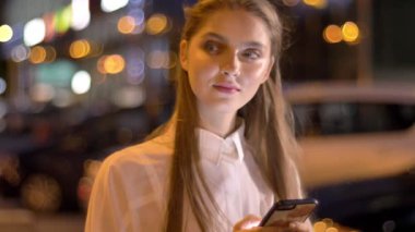 Genç güzel yer kız ileti, onun Smartphone'da akşam yaz, düşünme kavramı, iletişim kavramı yazmakta olduğunu
