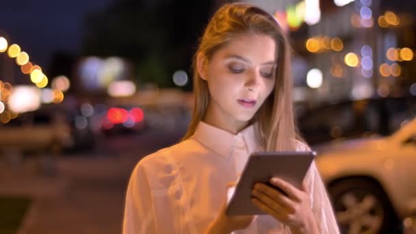 Jeune fille sérieuse lit le message sur sa tablette en soirée en été, concept de communication — Video