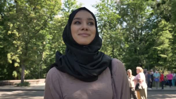 Joven chica musulmana feliz en hijab está sonriendo e ir a la universidad durante el día en verano, concepto religioso, el estudio de concepto — Vídeo de stock