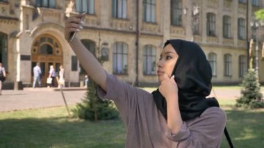 Hijab Müslüman kız Genç güzel selfie onun Smartphone'da yaz aylarında gündüz Bina arka plan, religiuos kavramı, iletişim kavramı üzerinde yapıyor