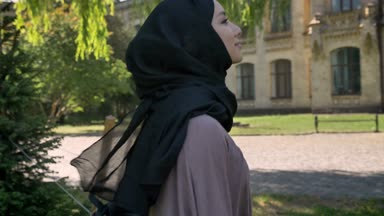 Genç Müslüman kıza hijab gülümseyen ve kavramı, yan görünümü okuyor yaz, dini kavramı, gündüzleri üniversiteye gidiş