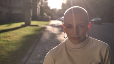 Yaz aylarında gündüz sokakta genç çekici olağanüstü cesur kız ayakta gülümseyerek, kameraya, flört anlayışı izlerken