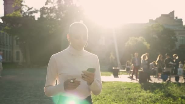 Buitengewone vet meisje loopt door park bij daglicht, in de zomer, horloge bericht op smartphone, glimlachen, communicatieconcept — Stockvideo