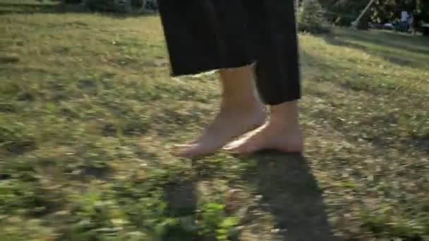 Legs of women walk on grass in park in daytime in summer, healthy lifestyle — Stock Video