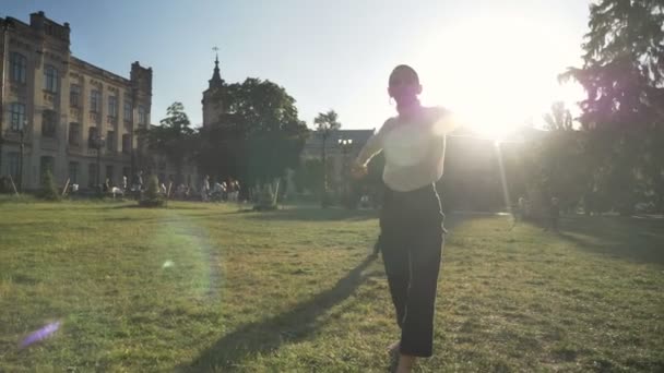 Młoda dziewczyna pogrubienie nadzwyczajne baleriny tańczy się na trawie w parku w świetle dziennym w lecie, koncepcja ruchu — Wideo stockowe