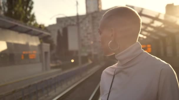 Triest buitengewone vet meisje wacht op trein op treinstation overdag in de zomer, stedelijk concept, denken concept — Stockvideo