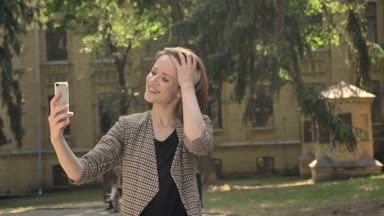 Genç çekici kız selfie parkta gündüz, yaz aylarında saç, iletişim kavramı dokunmadan yapıyor