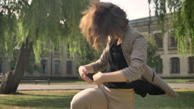 Genç güzel kız parkta gündüz, yaz aylarında hareket kavramı dans ediyor, Bina arka plan, Mevsimlik arka plan, yan görünüm, çekim dolly