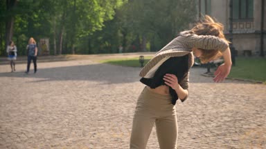 Genç güzel kız kameraya, hareket kavramı izlerken gündüz, yaz aylarında dans ediyor