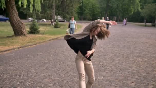 Молодая счастливая девушка танцует днем, летом, действуя руками, концепция движения — стоковое видео