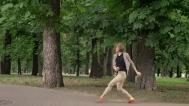 Genç güzel kız dansçı Park'ta dans gündüz, yaz, hareket kavramı, yan görünüm, dolly atış